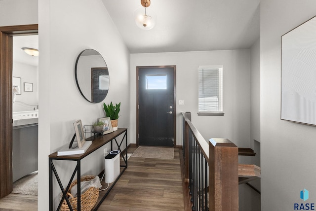 foyer entrance with vaulted ceiling and wood finished floors