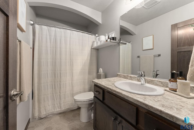 full bath featuring vanity, toilet, and visible vents