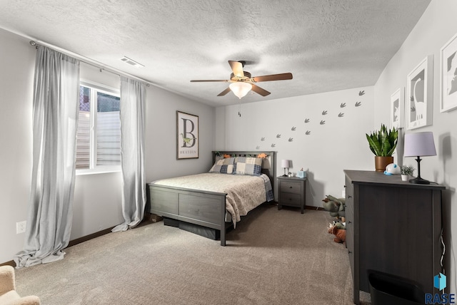 carpeted bedroom with baseboards, a ceiling fan, visible vents, and a textured ceiling