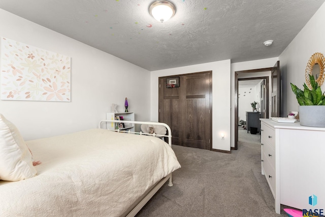 carpeted bedroom featuring a closet and a textured ceiling