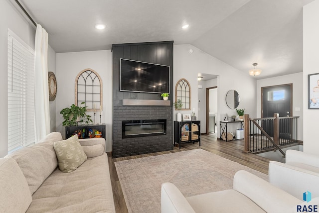 living area with wood finished floors, recessed lighting, a fireplace, and lofted ceiling