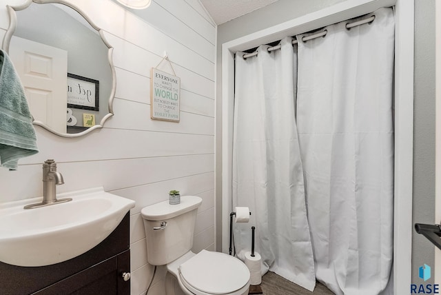 full bath with toilet, wood finished floors, a shower with shower curtain, wood walls, and vanity