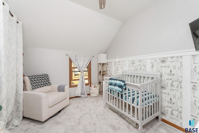 bedroom featuring visible vents, a crib, a ceiling fan, carpet, and lofted ceiling