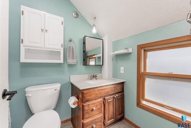 half bathroom with baseboards, toilet, vanity, vaulted ceiling, and a textured ceiling