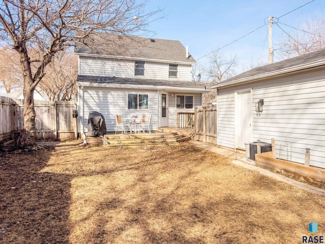 back of house with a deck and fence