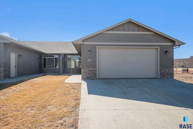 ranch-style home with a garage and stone siding