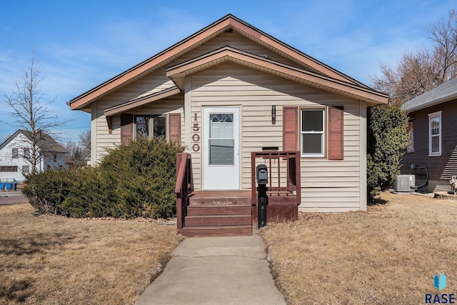 bungalow-style house with central AC unit and a front lawn