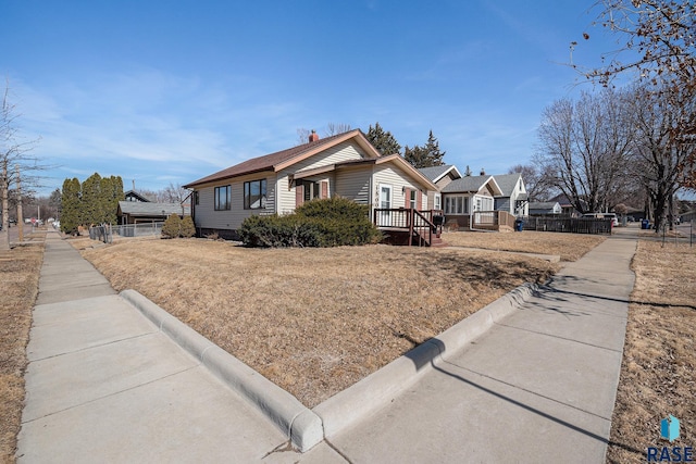 view of front of house featuring a deck and fence