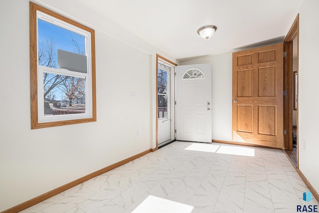 foyer entrance with baseboards and marble finish floor