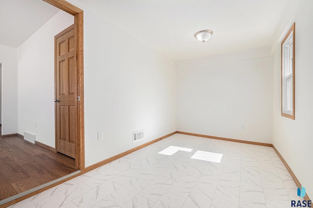 unfurnished room with visible vents, marble finish floor, and baseboards