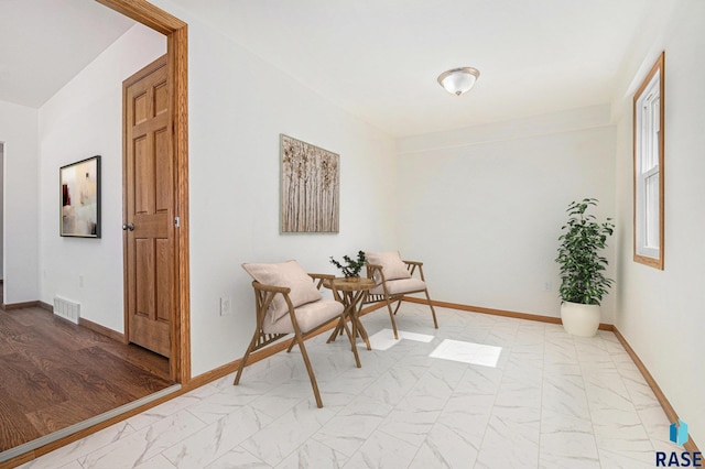 sitting room featuring visible vents, marble finish floor, and baseboards