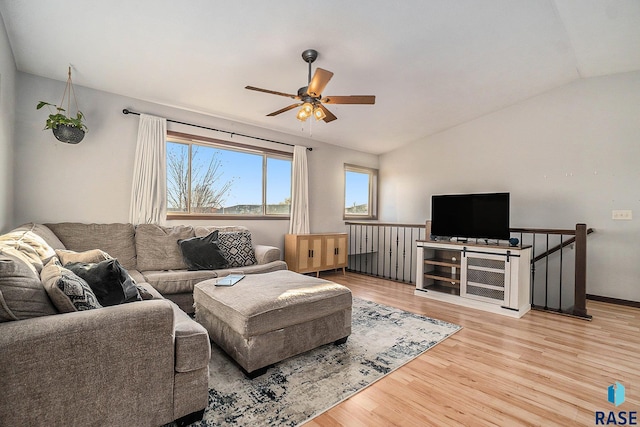 living area featuring a ceiling fan, lofted ceiling, and wood finished floors