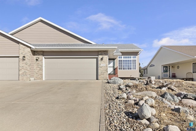 ranch-style house with a garage, brick siding, concrete driveway, and a shingled roof