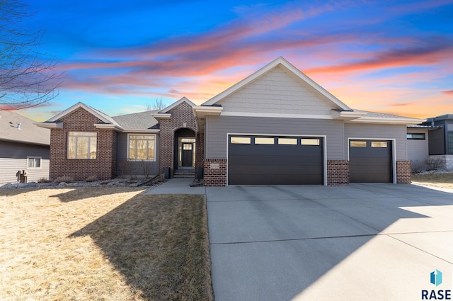 view of front facade with a garage, brick siding, and driveway