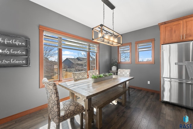 dining area with baseboards, an inviting chandelier, and dark wood finished floors