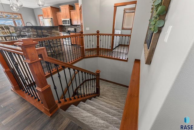 staircase featuring baseboards and wood finished floors