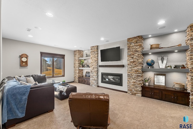 living area with visible vents, a textured ceiling, a glass covered fireplace, recessed lighting, and carpet