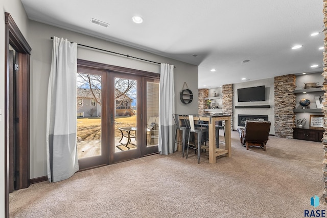 interior space featuring visible vents, carpet floors, recessed lighting, french doors, and a glass covered fireplace