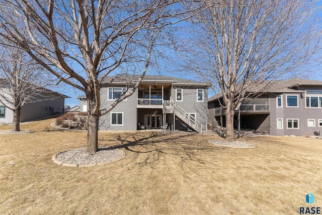 back of property with stairway and a lawn