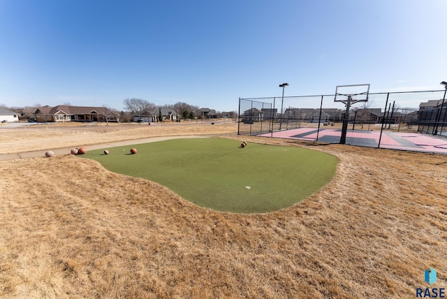 view of home's community with community basketball court and fence