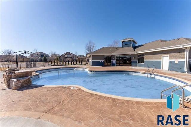 pool with a patio and fence