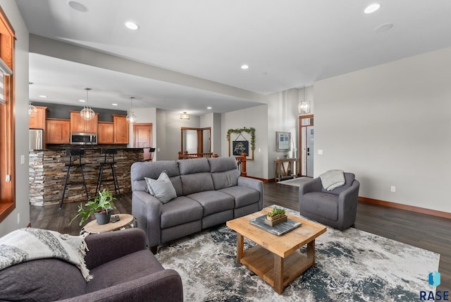 living room featuring dark wood-type flooring, recessed lighting, and baseboards