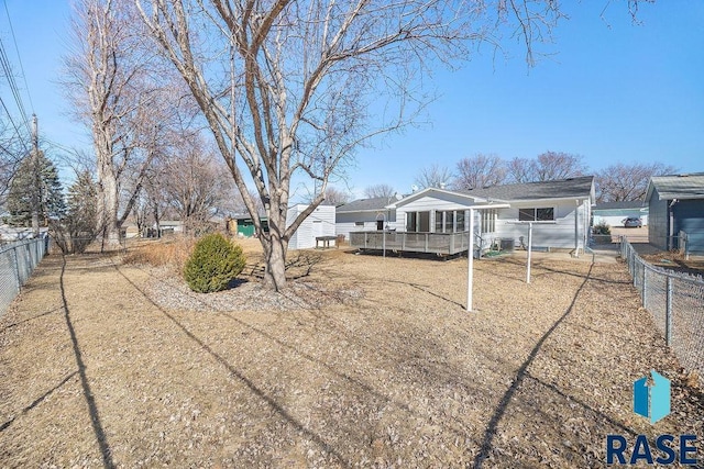 rear view of property with a deck and a fenced backyard