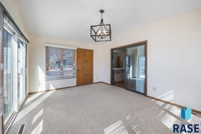 spare room with baseboards, a notable chandelier, carpet floors, and vaulted ceiling