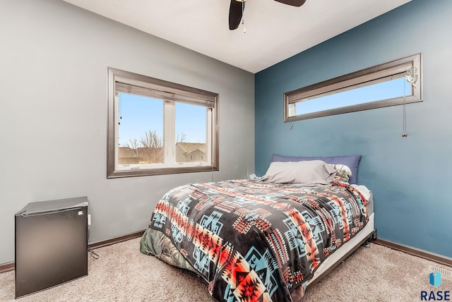 carpeted bedroom with baseboards and a ceiling fan