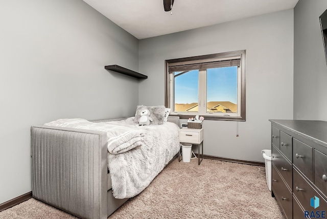 bedroom featuring light colored carpet, baseboards, and ceiling fan