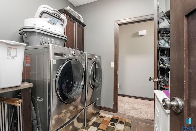 clothes washing area featuring cabinet space, washing machine and dryer, light carpet, and baseboards