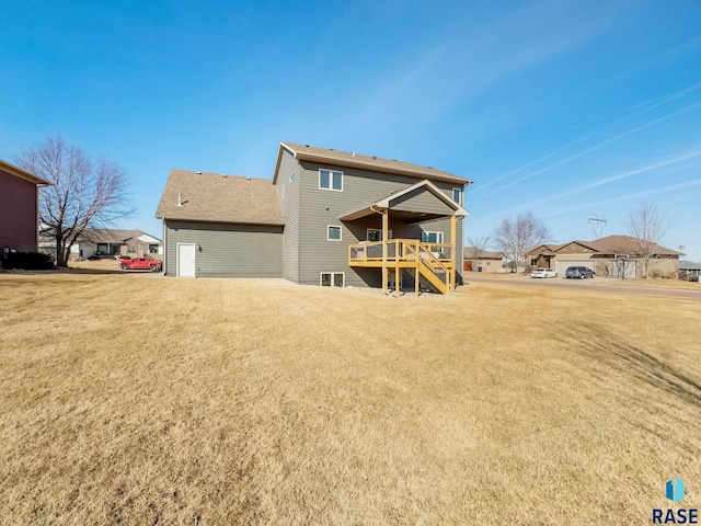 back of property with stairs and a lawn