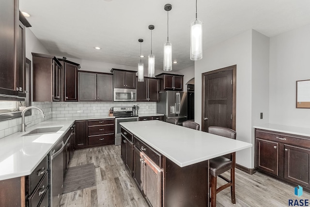 kitchen featuring a sink, stainless steel appliances, tasteful backsplash, and dark brown cabinetry