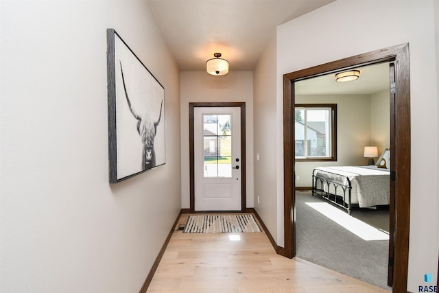 entryway with baseboards and light wood-type flooring