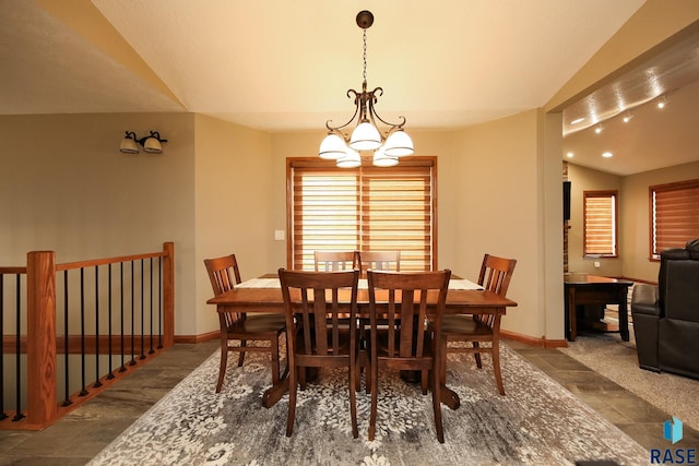 dining area with baseboards, lofted ceiling, and a notable chandelier