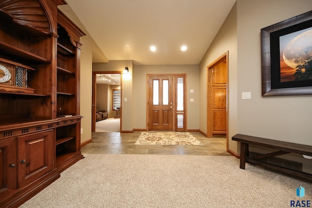 foyer featuring recessed lighting, baseboards, lofted ceiling, and light carpet