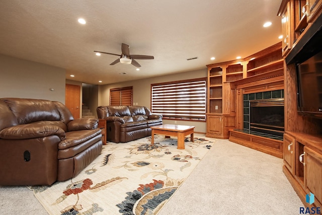 living area featuring visible vents, ceiling fan, light carpet, recessed lighting, and a tile fireplace