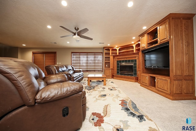 carpeted living area with recessed lighting, a textured ceiling, ceiling fan, and a fireplace