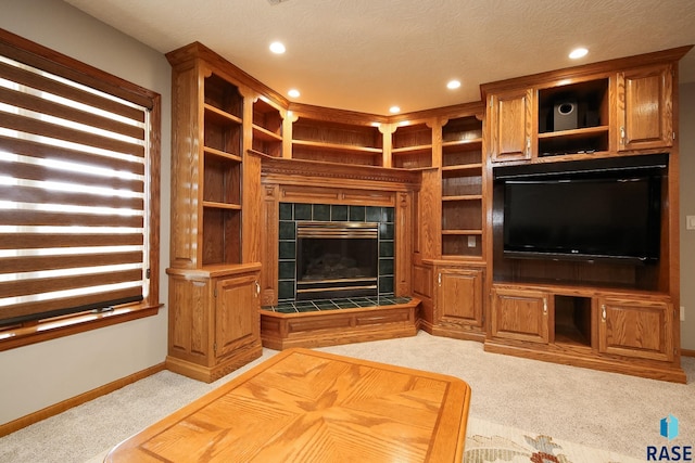 unfurnished living room with carpet flooring, recessed lighting, baseboards, and a tile fireplace