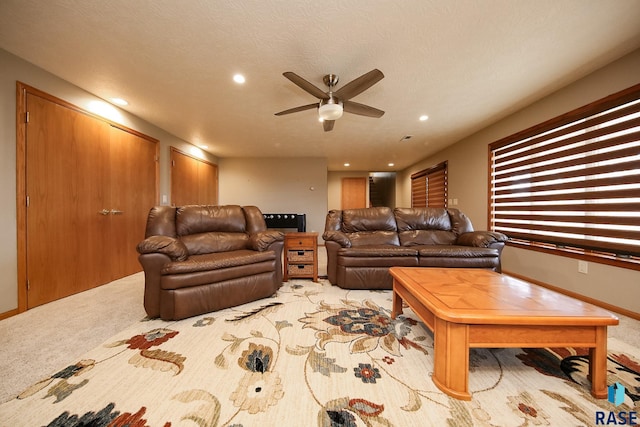 living room with recessed lighting, light colored carpet, a ceiling fan, and a textured ceiling