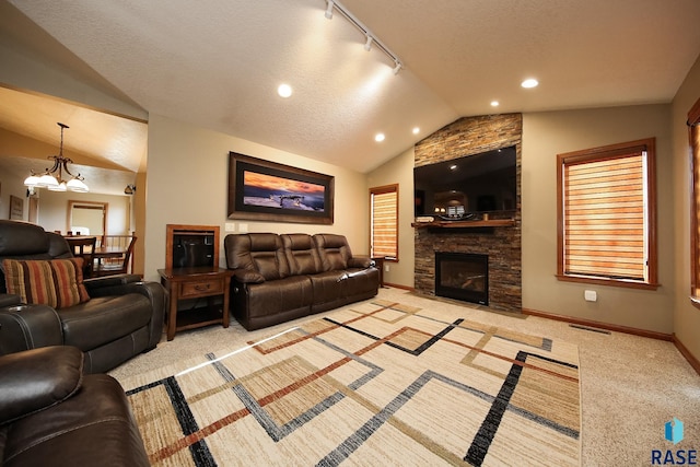 living room featuring baseboards, light colored carpet, lofted ceiling, a fireplace, and a textured ceiling