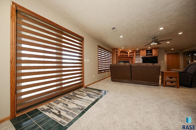 interior space with a textured ceiling, recessed lighting, carpet, a fireplace, and baseboards