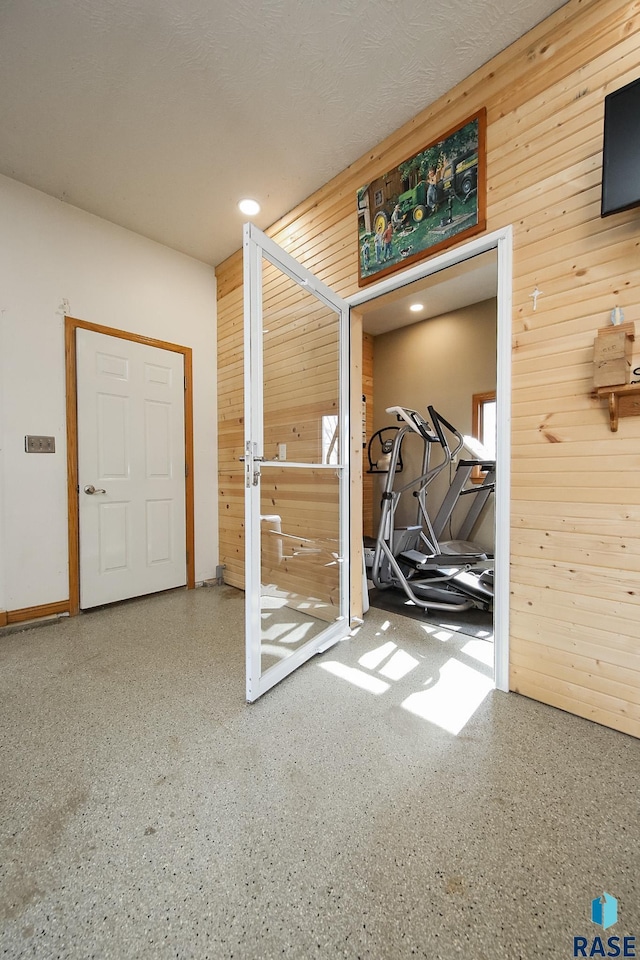 interior space featuring speckled floor and wood walls