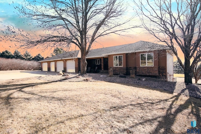 single story home with stone siding, an attached garage, and driveway