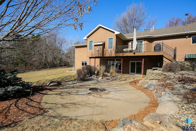 rear view of property featuring a wooden deck and a patio area