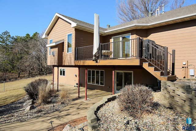 rear view of property with stairs and a patio