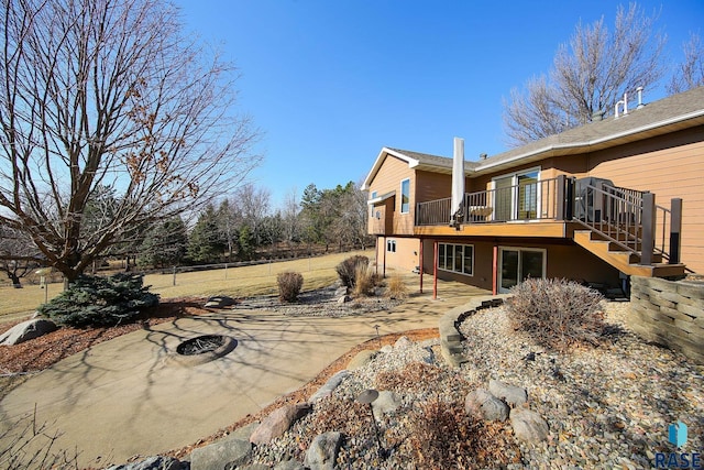 back of house featuring a patio area, stairway, a fire pit, and a deck