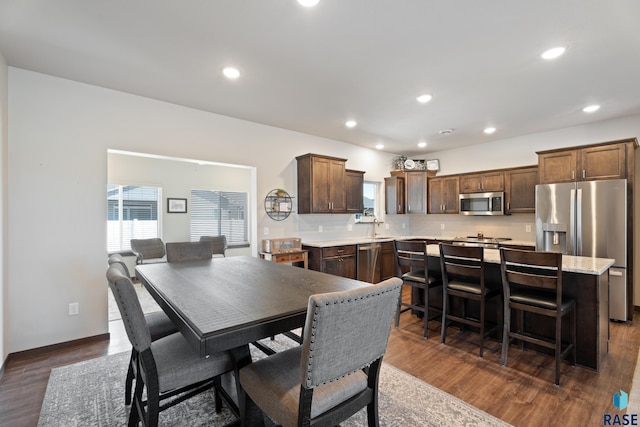 dining space featuring dark wood finished floors, recessed lighting, and baseboards