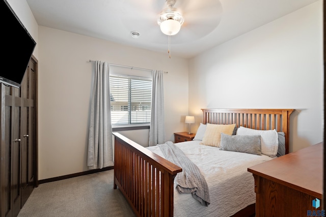 carpeted bedroom with ceiling fan and baseboards