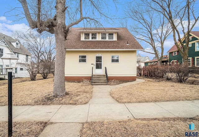 bungalow featuring roof with shingles and entry steps